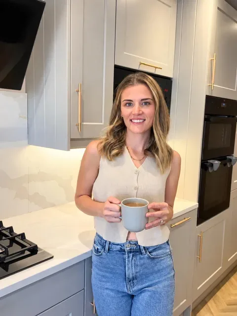 Ellis in her kitchen holding a mug of tea